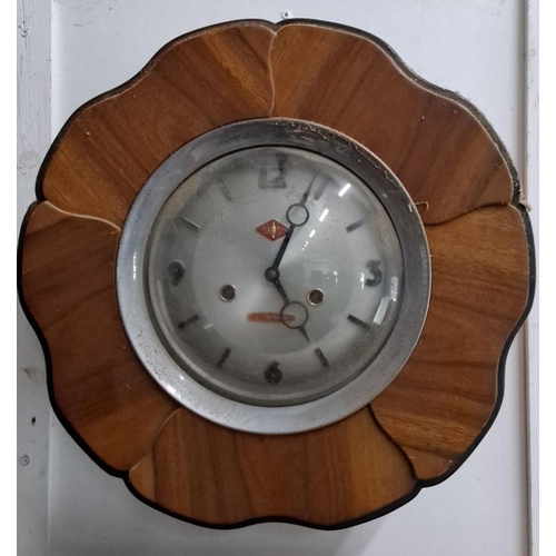 617 - Vintage wall clock with a circular metal face and wooden petal-shaped frame. Features Arabic numeral... 