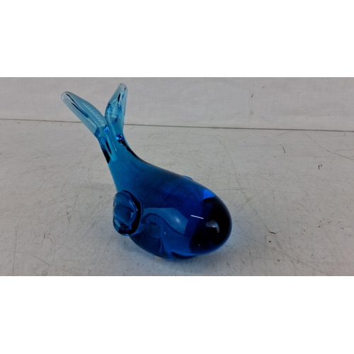 624 - Blue glass whale figurine with smooth curves and simplistic detailing features deep blue hues and ha... 