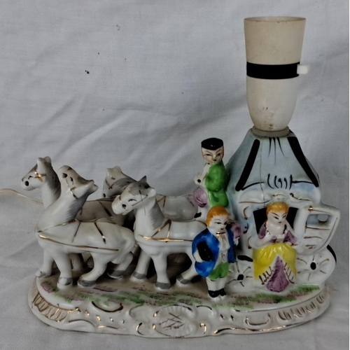 77 - Hand-painted porcelain table lamp with a carriage scene inclusive of figures and horses. The base is... 