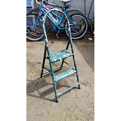 654 - Two-step metal ladder with green painted finish, folding design.