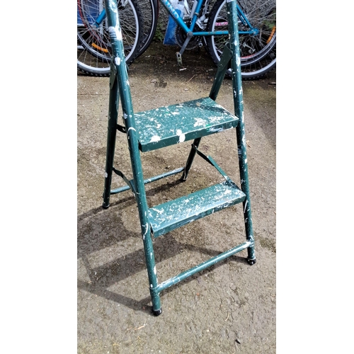 654 - Two-step metal ladder with green painted finish, folding design.