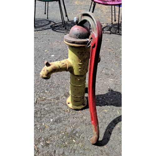 661 - Vintage cast iron water pump with red handle, yellow body. Classic early to mid-20th century design.