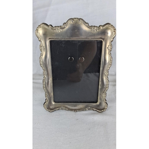 1187 - Vintage silver-tone ornate photo frame with intricate scrolling design, velvet backing, and easel st... 