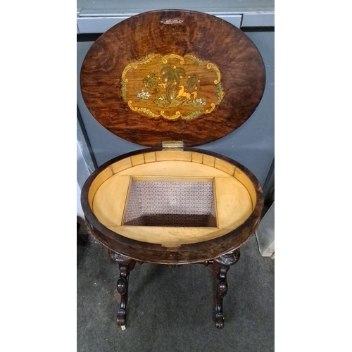 1215 - Victorian walnut sewing table featuring an oval top, an interior lid with decoration, and a storage ... 