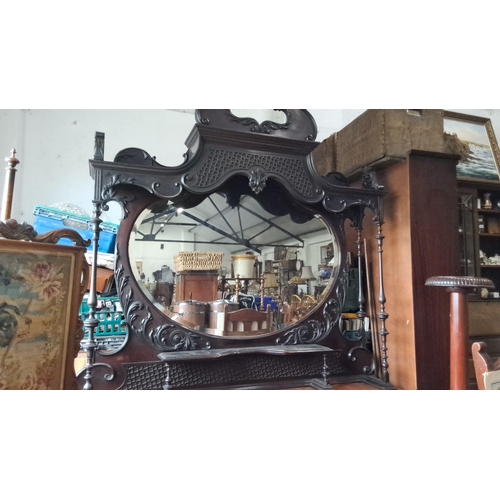 1239 - Victorian dark wood overmantel mirror with ornate carvings and a central oval glass. Approximately l... 