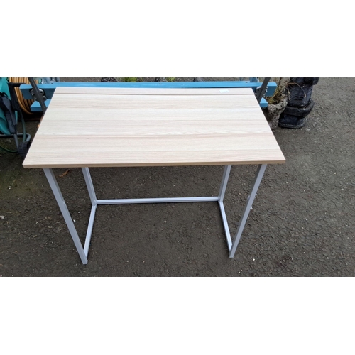 1240 - Modern foldable desk with light wood top and white metal legs.