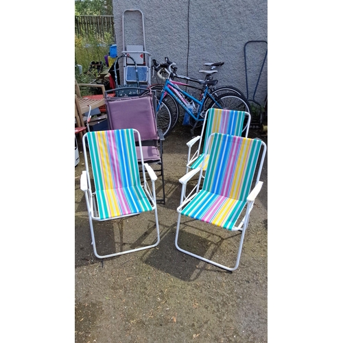 643 - Set of four colorful lawn chairs with striped fabric and white metal frames.