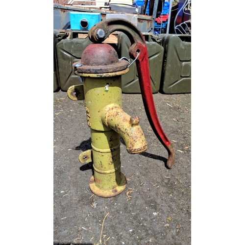 661 - Vintage cast iron water pump with red handle, yellow body. Classic early to mid-20th century design.