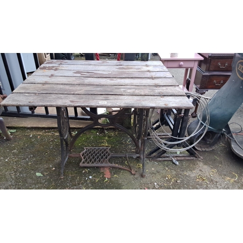 668 - Antique treadle Singer sewing machine table, now a rustic wooden table. Iron base with intricate det... 