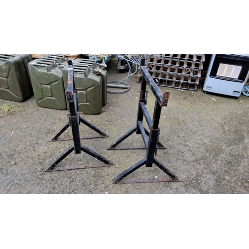 671 - Pair of sturdy black metal sawhorses with chain supports. Simple and functional design.