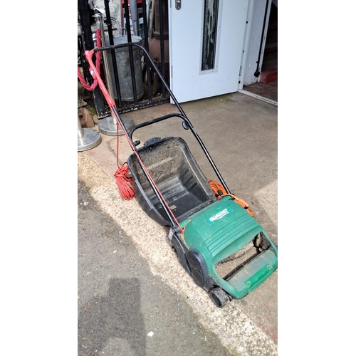 675 - Qualcast electric lawn mower with grass collection box and long extension cord.