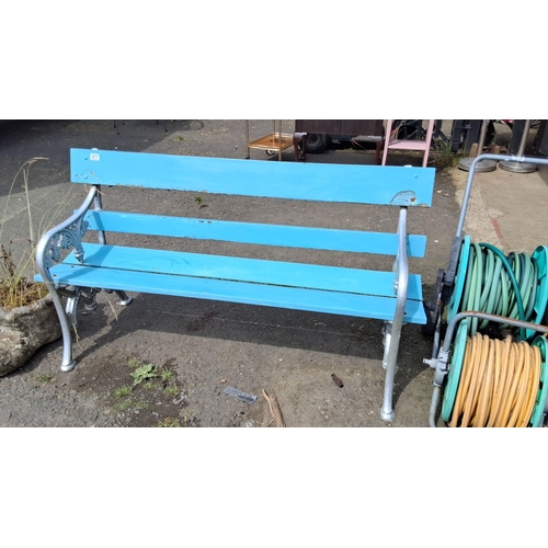 677 - Outdoor metal and wooden bench with light blue painted slats and intricate cast iron side frames.