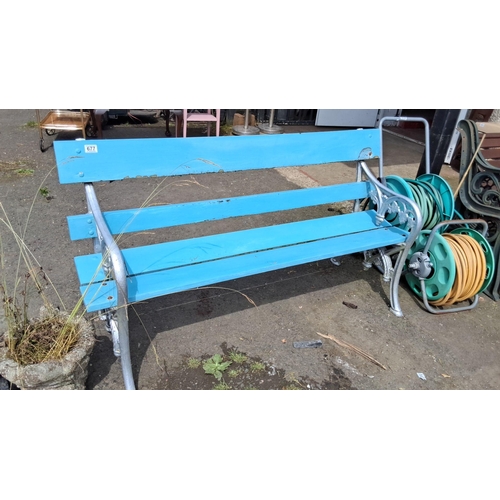 677 - Outdoor metal and wooden bench with light blue painted slats and intricate cast iron side frames.