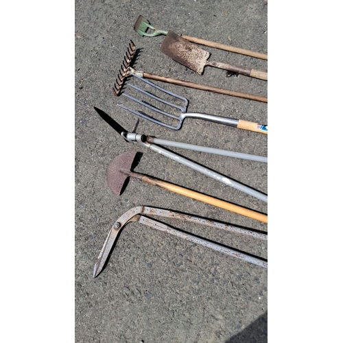 684 - Mixed lot of eight gardening tools. Includes a weed cutter, hoe, cultivator, shovel, spade, pitchfor... 