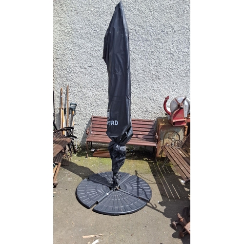 689 - Black outdoor patio umbrella with a sturdy base. It features an adjustable stand and a protective co... 