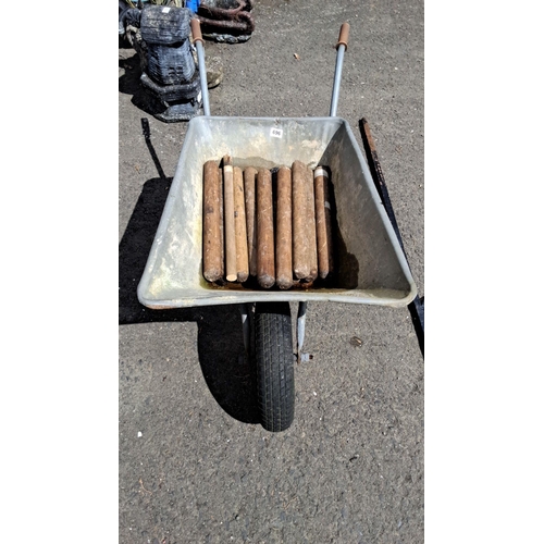 696 - Galvanized steel wheelbarrow with rubber hand grips and pneumatic tire, includes wooden dowels.