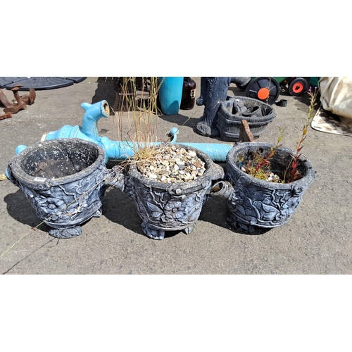 698 - Set of three intricately carved stone planters with floral motifs. Each planter sits on four decorat... 