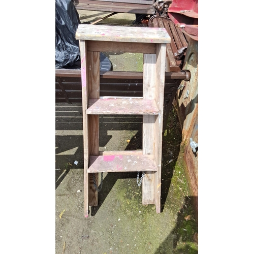 702 - Wooden step ladder with three steps and side support chains. Rustic condition with traces of paint.