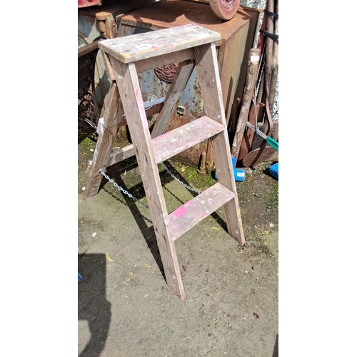 702 - Wooden step ladder with three steps and side support chains. Rustic condition with traces of paint.