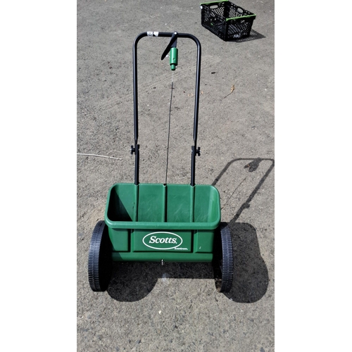 703 - Scotts EvenGreen push spreader for lawn care, featuring a sturdy green plastic hopper and durable wh... 