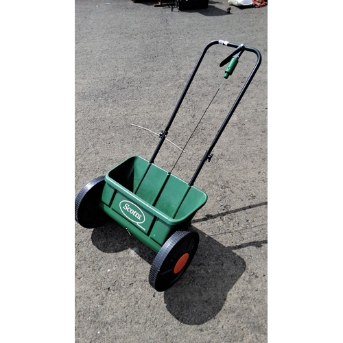 703 - Scotts EvenGreen push spreader for lawn care, featuring a sturdy green plastic hopper and durable wh... 