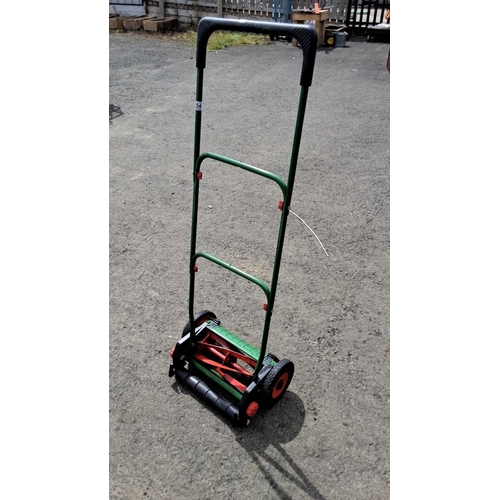 704 - Manual push lawn mower with a green metal frame and dual black wheels. Equipped with red reel blades... 