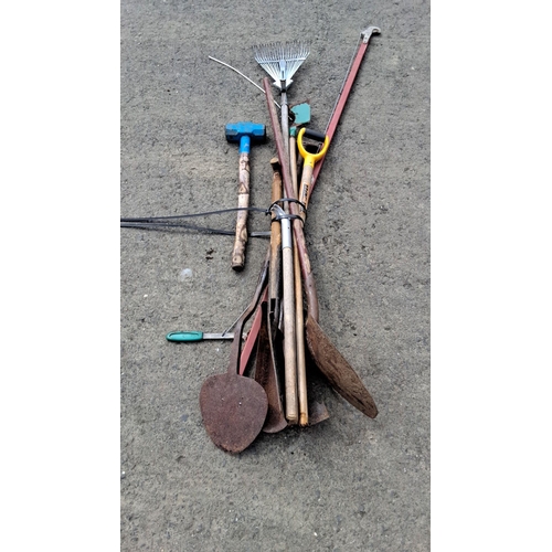 705 - Assorted garden and construction tools, including a rake, sledgehammer, pry bar, shovel, and post-ho... 