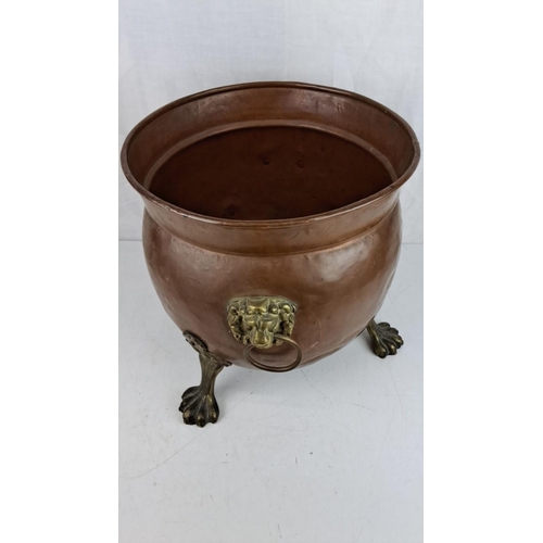 10 - Large Victorian copper cauldron/planter with brass lion head handles and paw feet, circa late 19th c... 