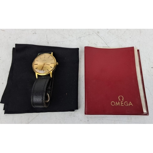 158 - Vintage Omega Genève wristwatch with a gold-tone case and a black leather strap. Comes with an origi... 