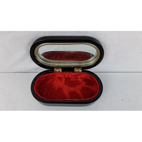 175 - A decorative jewellery box depicting traditional figures. It has a red velvet interior and a mirror ... 