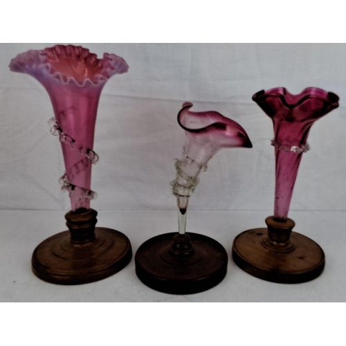 27 - Set of three Victorian cranberry glass epergnes. They have fluted and ruffled edges, adorned with an... 