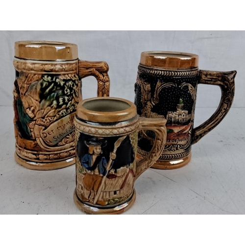 37 - Three vintage ceramic beer steins, each with intricate hand-painted designs and inscriptions.