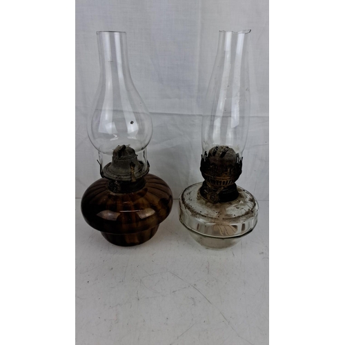 49 - Pair of vintage oil lamps, one with an amber glass base and the other with a clear glass base. Both ... 