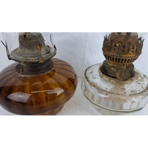 49 - Pair of vintage oil lamps, one with an amber glass base and the other with a clear glass base. Both ... 