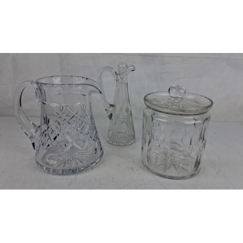 65 - Three-piece cut glass set, including a pitcher, a carafe, and a lidded biscuit jar, all detailed wit... 