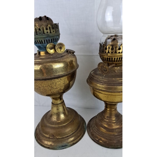 7 - Two vintage brass oil lamps with intricate wick adjustment mechanisms and chimney holders. One is ma... 