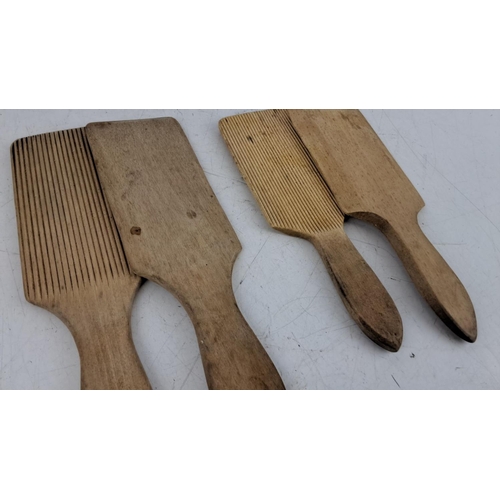 73 - Four vintage wooden butter paddles, each with a grooved and smooth side.