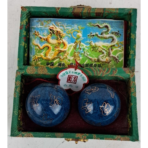 74 - Two Chinese medicine balls come in a Decorative Box. Two blue metal balls with gold pattern detail.