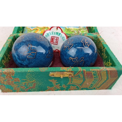 74 - Two Chinese medicine balls come in a Decorative Box. Two blue metal balls with gold pattern detail.