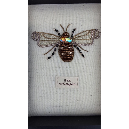 92 - Framed textile artwork depicting a bee, labeled 