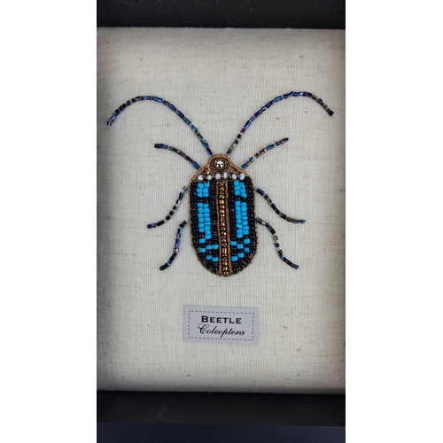 95 - Framed beaded artwork of a beetle ('Coleoptera'), featuring intricate turquoise, black, and gold bea... 