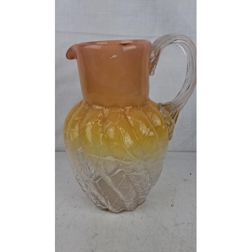 189 - Vintage ombre glass pitcher in orange, yellow, and clear hues. The jug features a textured body with... 