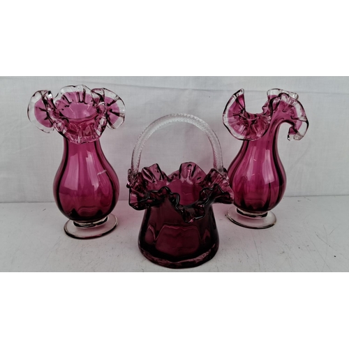 198 - Set of three ruby art glass pieces. Includes two vases and one handled basket, each showcasing intri... 