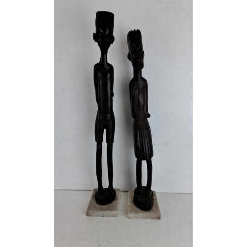 216 - Pair of African tribal figurative wooden sculptures on marble bases. Each intricate carving showcase... 