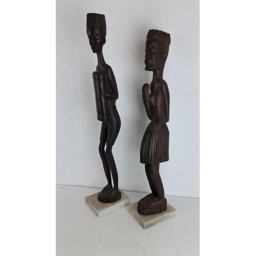 216 - Pair of African tribal figurative wooden sculptures on marble bases. Each intricate carving showcase... 