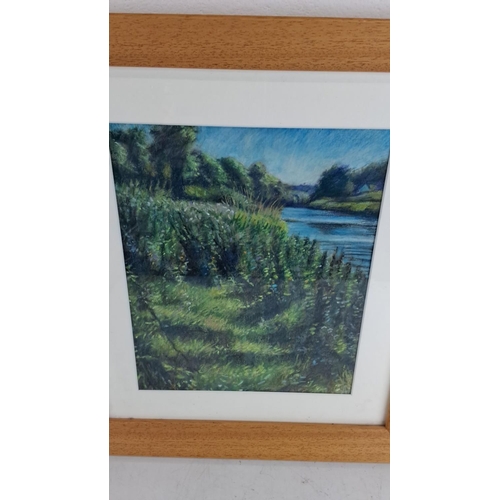 219 - Framed landscape painting depicting a  riverside scene with lush greenery, created with soft pastels... 