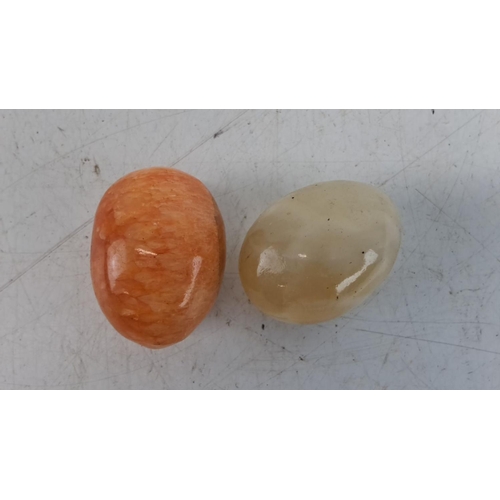 223 - Pair of polished gemstone eggs: one in orange calcite and one in beige onyx. Smooth finish highlight... 