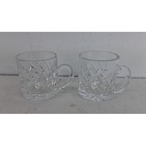 230 - Pair of crystal mugs with intricate diamond-cut patterns and sturdy handles.