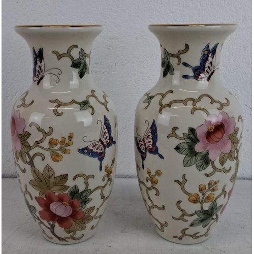 239 - Pair of small porcelain vases with floral and butterfly motifs, accented with gold trim.