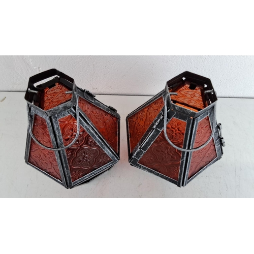 241 - Pair of interictally designed tealight lanterns with embossed red glass panels, housed in distressed... 